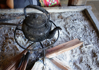 The hot kettle is boiling on the firewood stove.