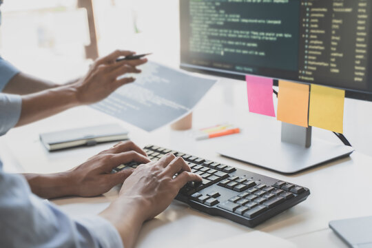 Programming developing software application. programmer writing program code with two monitors and working hacker on a new software