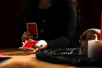 Soothsayer predicting future with cards at table indoors, closeup