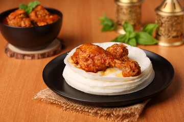 Rice pathiri  Pathir flat bread with spicy chicken curry, Kerala Tamil Nadu India SriLanka. Popular traditional South Indian breakfast dish of Malabar Muslims on Ramadan Ramzan, Eid festival Rice roti