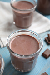 Delicious chocolate milk on light blue wooden table
