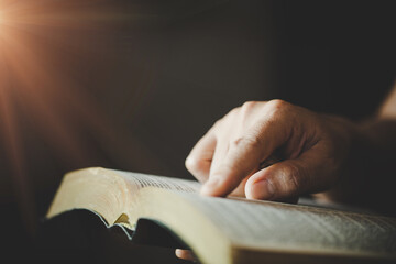 woman's hands while reading the Bible.