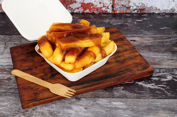 Chips and gravy meal in a take away box with lid