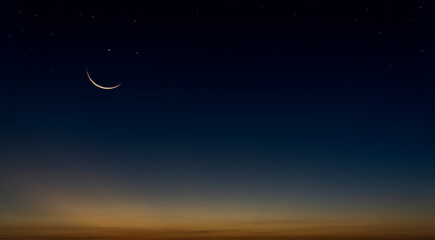 Crescent moon and star on dark blue sky after sundown, symbol for Islamic in Ramadan,Eid al-Adha, Eid al-fitr and free space for arabic text present 
