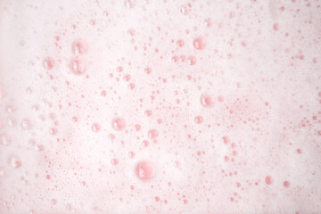 White foam bubbles texture on pink pastel background, copy space, banner for loundry, cleaning...