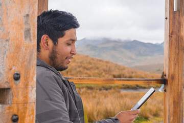 Young guy sitting in gazebo in mountains and enjoying the beautiful view