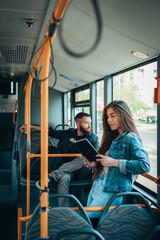 Woman reading a book while standing in the moving bus © Zamrznuti tonovi
