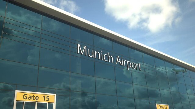 Taking off airplane reflecting in the modern windows with Munich Airport text