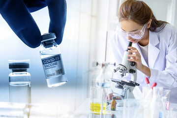 Fototapeta premium Concept fight against virus covid-19 corona virus, doctor or scientist with a microscope with hand of doctor holding COVID-19 vaccine bottle, adults, Concept: diseases, medical care, science.