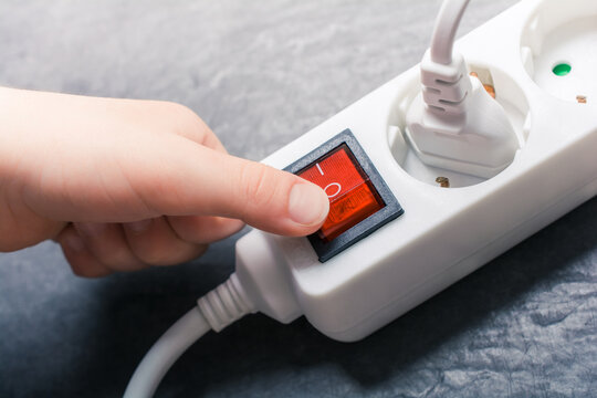 Child Hand Pressing Red Switch On A Power Strip - Prevent Child Hazard Concept