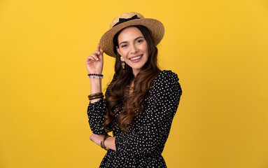 pretty woman posing isolated on yellow background wearing straw hat and dress