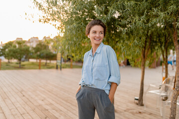 Fototapeta premium young pretty woman in casual summer style in modern park street