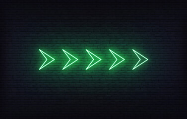 Neon arrow sign. Set of green futuristic glowing neon arrow pointer on brick wall background