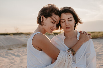 Fototapeta na wymiar two young women having fun on the sunset beach
