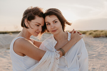 Fototapeta na wymiar two young women having fun on the sunset beach