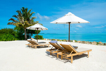 Beautiful landscape with sunbeds and umbrellas on the sandy beach, Maldives island