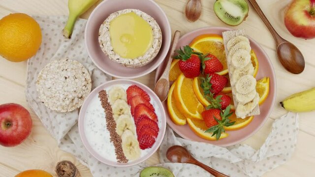 Sweet breakfasts. Granola with strawberries and banana and freshly chopped orange wedges, garnished with various fruits, sweet breakfasts