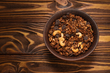 Chocolate granola cereal with nuts in a bowl.