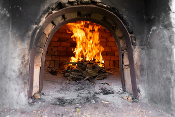 Fire inside a brick furnace burning to heat the oven for the preparation of a lamb