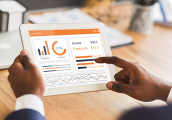 Cropped of african american businessman analysing spendings on digital tablet