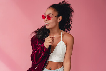 attractive black african american woman in stylish outfit on pink background