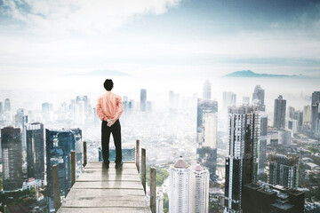 Fototapeta na wymiar Young businessman looking at the misty city