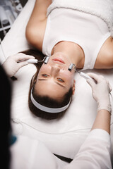 Galvanic therapy and hardware cosmetology. Beautician does elecrtotherapy facial facelift for smooth healthy client skin, nourish skin and boost oxygen into face cells, prolong youthful healthy look