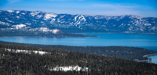 Scenic view of Lake Tahoe, in the Sierra Nevada Mountain Range of California, as shot from Alpine Meadows, with the runs Diamond Peak ski resort in the background.  - obrazy, fototapety, plakaty