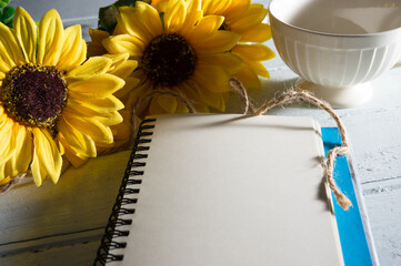 Paper book page with sunflowers and coffee cup.