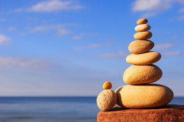 Rock zen pyramid of colorful pebbles on the background of the sea. Concept of Life balance
