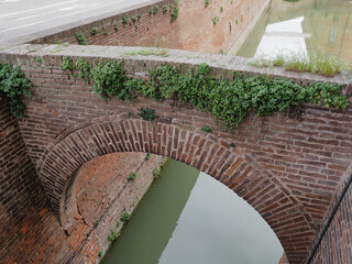 Ferrara, Italy. Estense castle, moat with water, detail.
