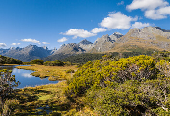 alpine lake at Key Summit Track in Fiordland National Park, South Island, New Zealand with blue sky and copy space