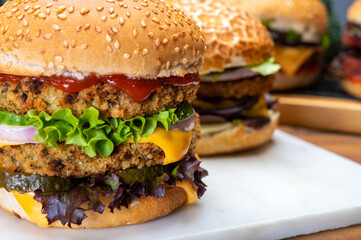 Tasty vegetarian cheeseburgers and hamburgers with round patties or burgers made from grains, vegetables and legumes