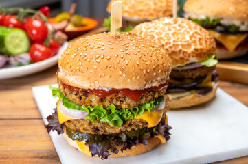 Tasty vegetarian cheeseburgers and hamburgers with round patties or burgers made from grains, vegetables and legumes