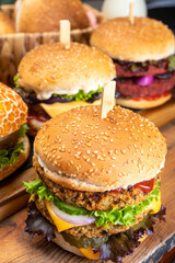 Tasty vegetarian cheeseburgers and hamburgers with round patties or burgers made from grains, vegetables and legumes