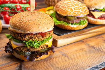 Tasty vegetarian cheeseburgers and hamburgers with round patties or burgers made from grains,...