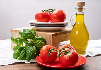 Vegetarian food - ripe red sweet tomatoes, green basil and extre virgin olive oil
