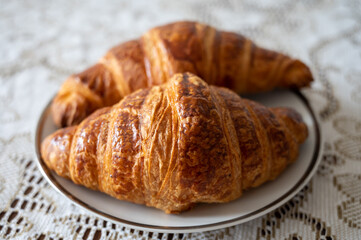 Two fresh baked puff croissants, traditional French breakfast