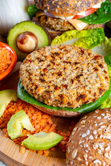 Tasty vegetarian healthy food, homemade burgers made from orange lentils legumes with green lettuce and fresh ripe avocado
