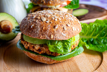 Tasty vegetarian healthy food, homemade burgers made from orange lentils legumes with green lettuce and fresh ripe avocado