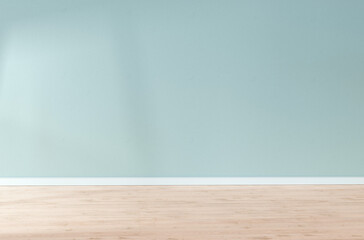 Light blue textured wall and wooden floor in empty room for displaying your product, light coming...