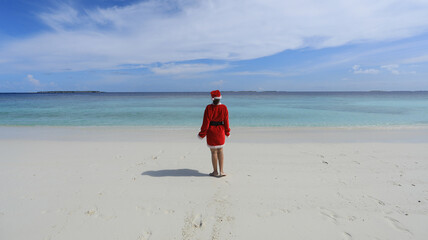 woman santa claus on the shore of a tropical island