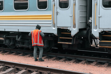 An employee of the railway station serves a train carriage