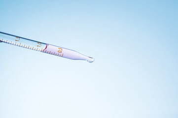 Medical laboratory. Pipette with pink liquid on a blue background. Laboratory tests.