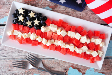 American flag salad with watermelon, blueberries and feta cheese. Top view table scene against a rustic wood background. Fourth of July food concept.