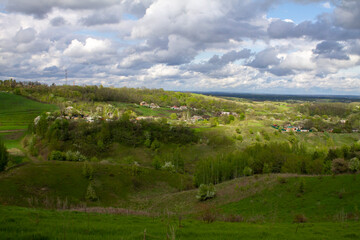Fototapeta na wymiar Ukrainian village, spring hills, houses and forest