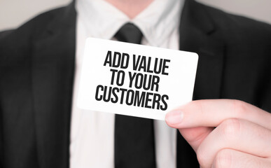 Businessman holding a card with text ADD VALUE TO YOUR CUSTOMERS