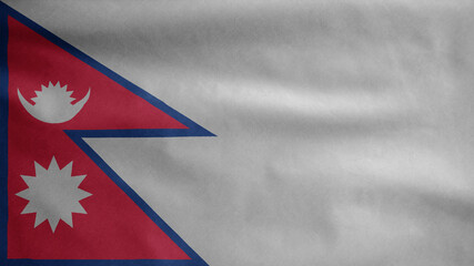 Nepalese flag waving in the wind. Close up of Nepal banner blowing soft silk.