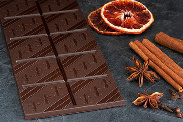 Dark chocolate bar  and spices. on dark marble background.Top view with copy space.