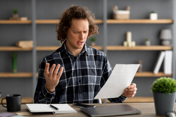 Discontented Businessman Reading Negative Business Report Having Problem In Office